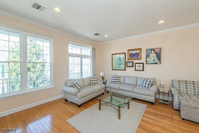 living area featuring visible vents, light wood-style flooring, crown molding, and baseboards