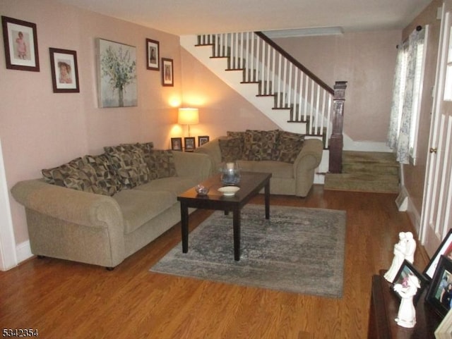 living room with stairs, baseboards, and wood finished floors