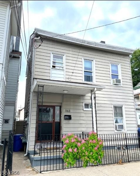 townhome / multi-family property featuring a fenced front yard and cooling unit