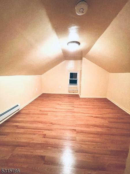 bonus room with vaulted ceiling, baseboards, and wood finished floors