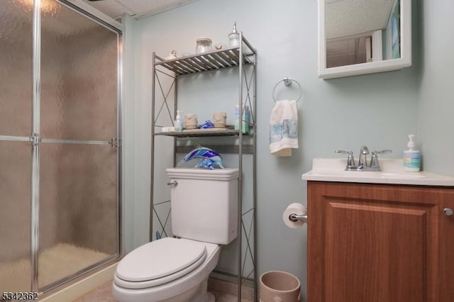 bathroom featuring vanity, a shower stall, and toilet