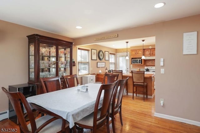 dining room featuring light wood finished floors, baseboards, and recessed lighting