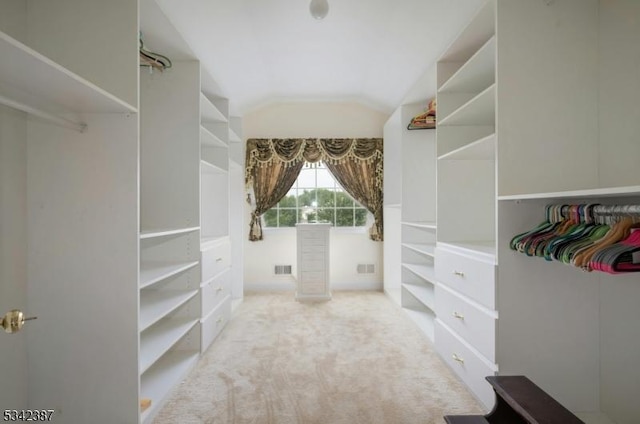 walk in closet with lofted ceiling, carpet flooring, and visible vents