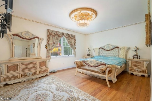 bedroom with baseboards and wood finished floors