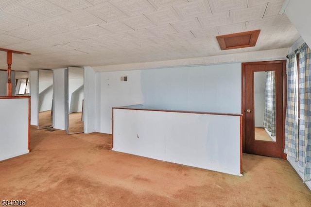 carpeted spare room featuring visible vents