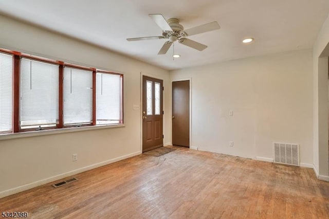 unfurnished room featuring recessed lighting, wood finished floors, visible vents, and baseboards