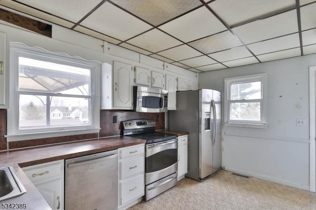 kitchen with visible vents, a drop ceiling, dark countertops, appliances with stainless steel finishes, and white cabinetry