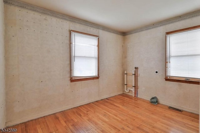 empty room featuring visible vents and light wood-style flooring