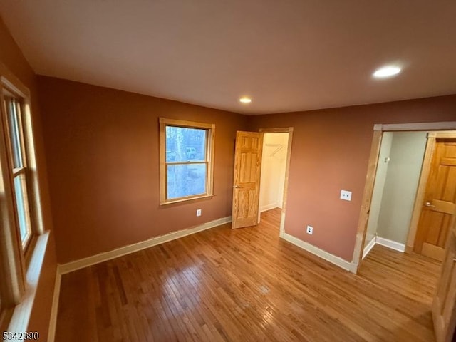 unfurnished bedroom with light wood-style floors, baseboards, and recessed lighting