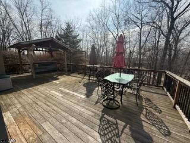 wooden deck featuring a gazebo and outdoor dining area