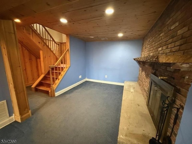 finished basement featuring recessed lighting, a fireplace, wood ceiling, baseboards, and stairs