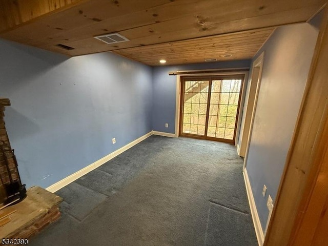 carpeted spare room featuring wood ceiling, visible vents, and baseboards