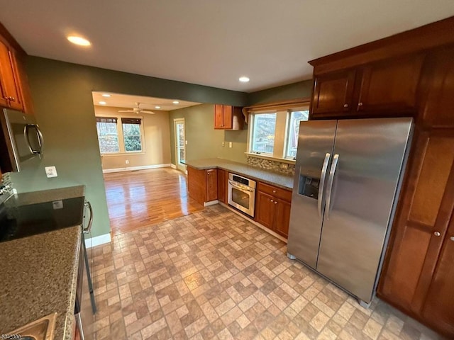 kitchen with appliances with stainless steel finishes, recessed lighting, brown cabinets, and baseboards