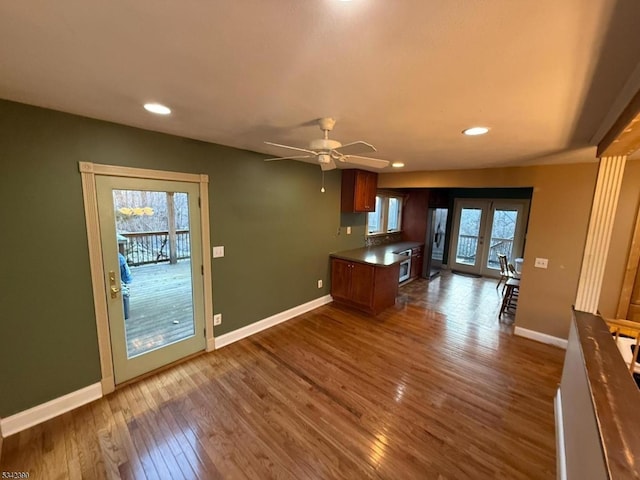 kitchen featuring a peninsula, french doors, dark wood-style flooring, and baseboards