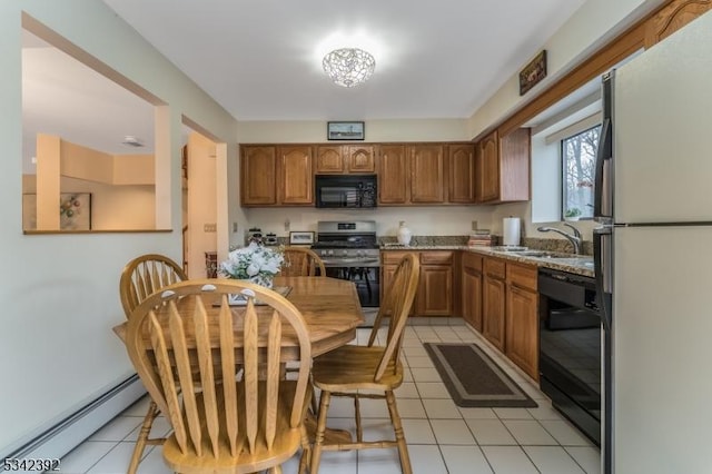 kitchen with light tile patterned floors, brown cabinets, baseboard heating, black appliances, and a sink