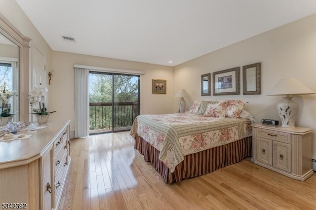 bedroom with light wood-type flooring, access to outside, and multiple windows