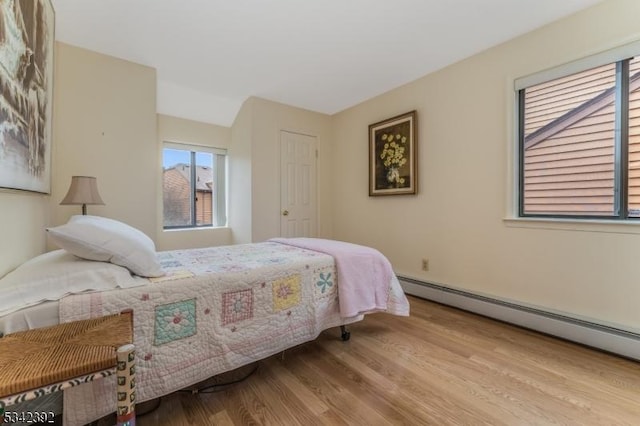 bedroom featuring a baseboard radiator and wood finished floors