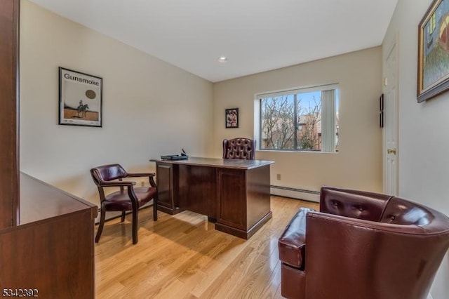 office area featuring a baseboard heating unit and light wood-type flooring