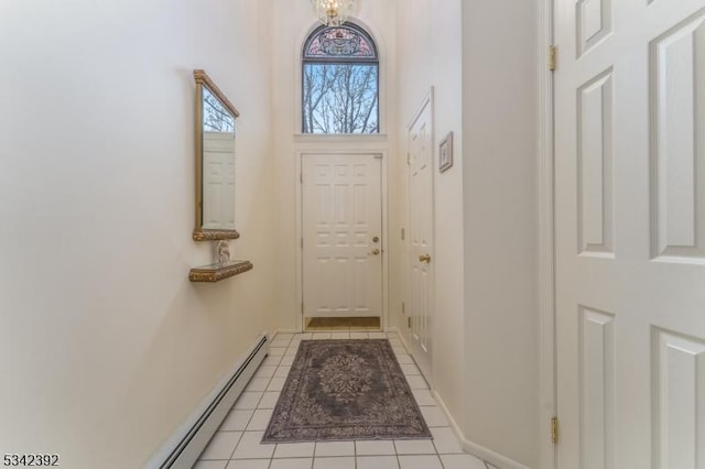 doorway to outside featuring light tile patterned floors, a high ceiling, and baseboards