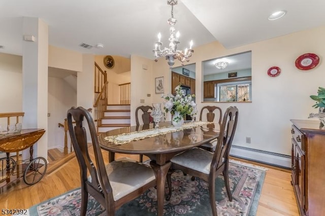 dining space with a baseboard radiator, stairway, and light wood-style flooring