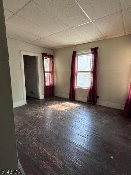 1 Reid Ave, Passaic City, NJ 07055 - interior space featuring baseboards, a drop ceiling, and hardwood / wood-style flooring