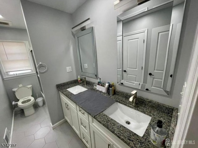 full bathroom with double vanity, tile patterned flooring, a sink, and toilet