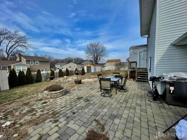 view of patio / terrace featuring fence private yard, an outdoor fire pit, a residential view, and outdoor dining space