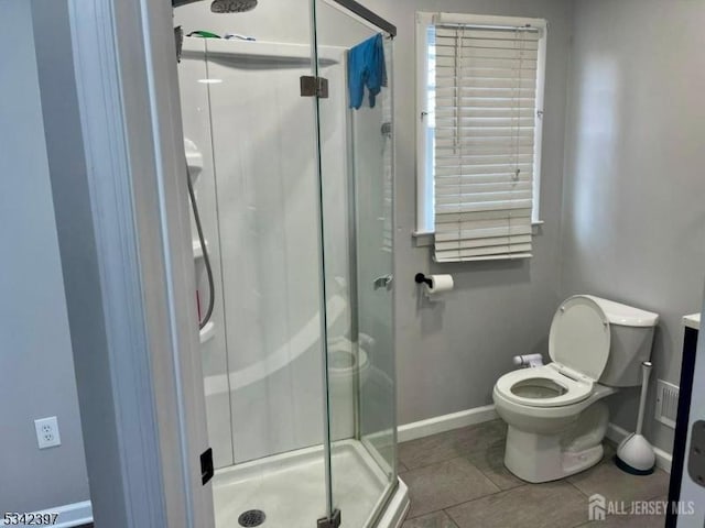 full bath featuring tile patterned flooring, baseboards, a shower stall, and toilet