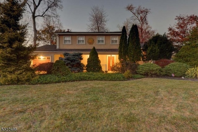 traditional-style house with a front yard and stucco siding