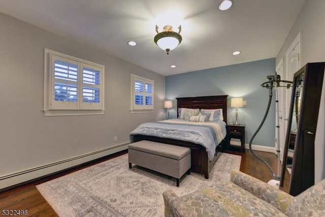 bedroom with a baseboard radiator, wood finished floors, and recessed lighting