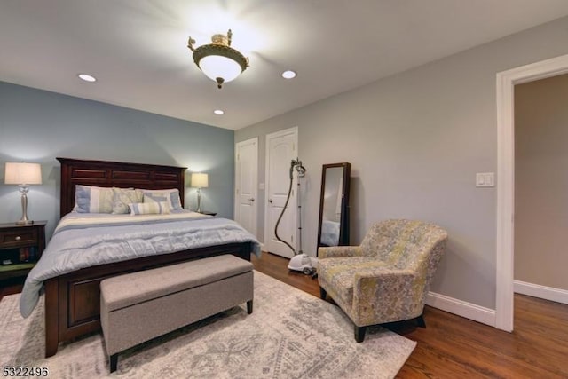 bedroom featuring baseboards, wood finished floors, and recessed lighting