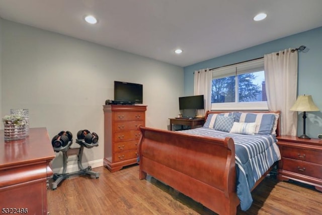 bedroom with baseboards, wood finished floors, and recessed lighting