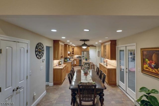 dining area featuring stone finish flooring, baseboards, french doors, and recessed lighting