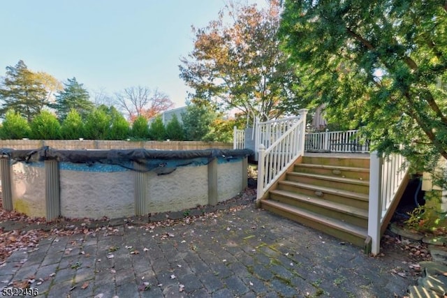 view of swimming pool featuring a fenced in pool, a patio area, stairway, and a wooden deck