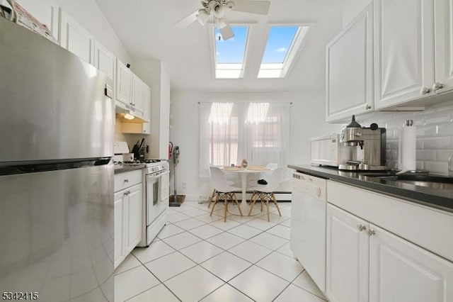 kitchen featuring light tile patterned floors, white cabinets, white appliances, and tasteful backsplash