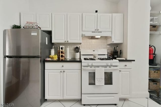 kitchen with tasteful backsplash, under cabinet range hood, white range with gas cooktop, freestanding refrigerator, and white cabinets