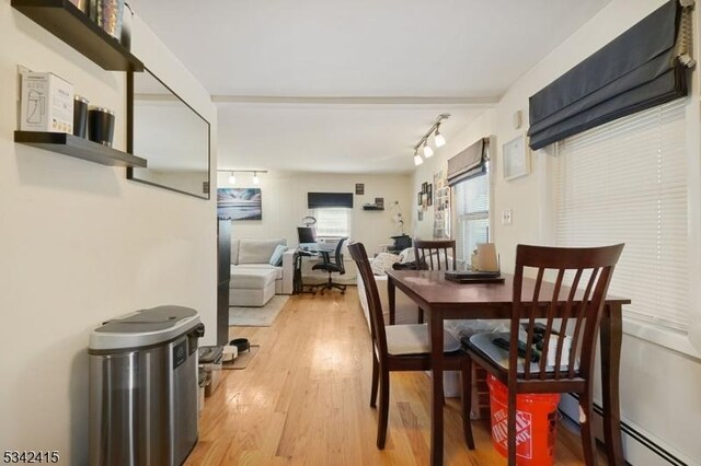 dining area featuring baseboard heating and light wood-style floors