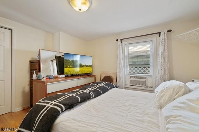 bedroom with cooling unit and wood finished floors