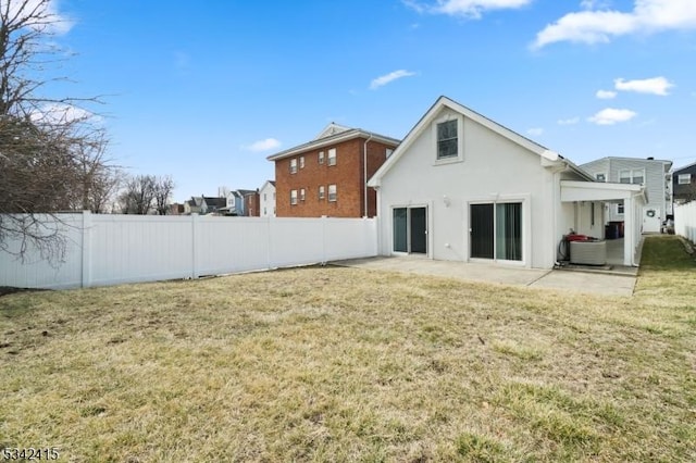 rear view of house featuring stucco siding, a lawn, a patio, a fenced backyard, and central AC unit