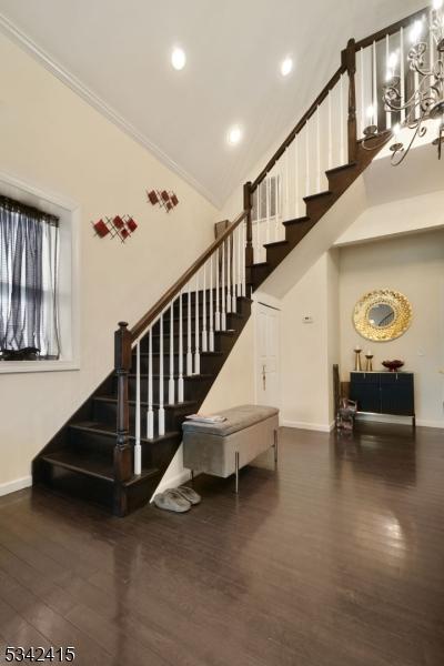 stairs with recessed lighting, high vaulted ceiling, baseboards, and wood finished floors