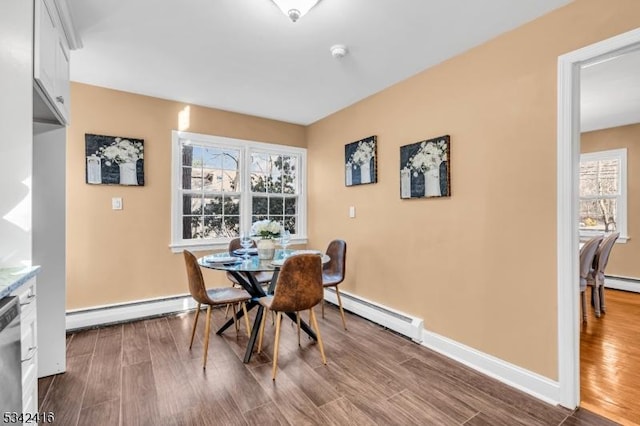 dining area with a baseboard heating unit, baseboards, dark wood finished floors, and baseboard heating