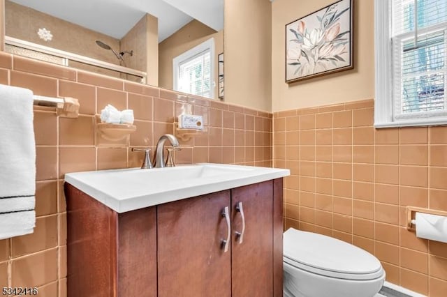 bathroom featuring tile walls, toilet, and vanity