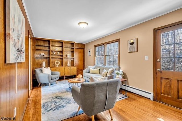 living room featuring a baseboard radiator, light wood-style flooring, and crown molding