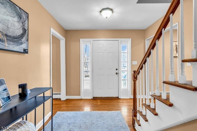 entrance foyer with a healthy amount of sunlight, baseboards, stairway, and wood finished floors