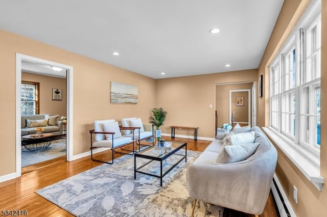 living room featuring recessed lighting, plenty of natural light, baseboards, and wood finished floors