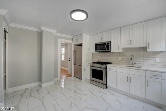 kitchen featuring a sink, marble finish floor, appliances with stainless steel finishes, decorative backsplash, and crown molding