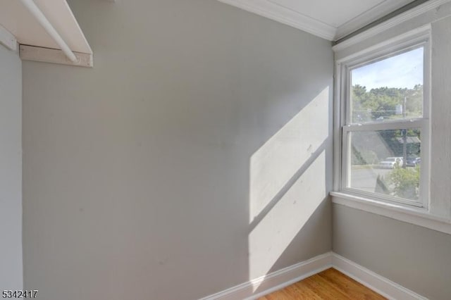 interior space with ornamental molding, light wood finished floors, and baseboards