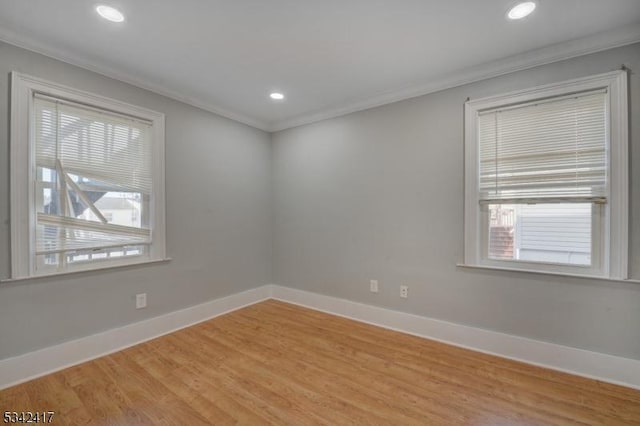 spare room with light wood finished floors, ornamental molding, recessed lighting, and baseboards