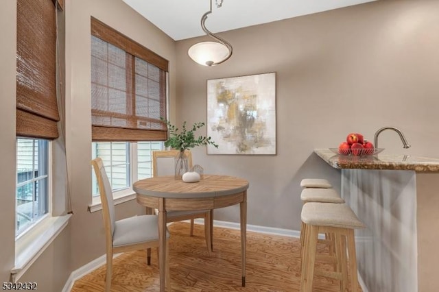 dining area with baseboards and wood finished floors