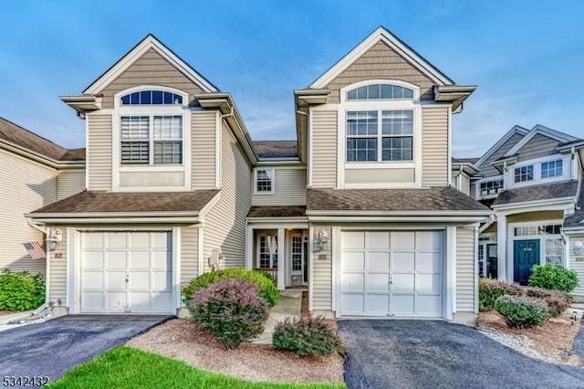 view of front of home with an attached garage, a shingled roof, and aphalt driveway